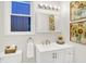 Bright bathroom featuring a white vanity, sunflower art, brushed gold faucet and a window bringing in natural light at 1339 S East St, Indianapolis, IN 46225