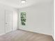 Bedroom featuring neutral carpet, window view, and white door at 1339 S East St, Indianapolis, IN 46225
