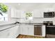 Bright kitchen offers stainless appliances, white cabinets, and tile backsplash at 1339 S East St, Indianapolis, IN 46225
