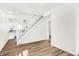 Open living room with wood-look floors and white staircase leading to kitchen at 1339 S East St, Indianapolis, IN 46225