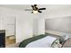 Light-filled primary bedroom with ensuite bathroom, ceiling fan, neutral decor, and a decorative green throw blanket at 1339 S East St, Indianapolis, IN 46225