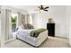 Comfortable primary bedroom featuring bright windows with curtains, ceiling fan, neutral carpet, and white walls at 1339 S East St, Indianapolis, IN 46225