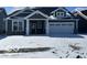 Charming one-story home featuring a two-car garage and classic architectural design, covered in fresh winter snow at 19726 Highclere Ln, Sheridan, IN 46069