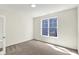 Minimalist bedroom featuring neutral carpet and a large window with blue siding views at 19726 Highclere Ln, Sheridan, IN 46069