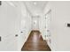 Long hallway with wood flooring, white doors, and neutral walls, showcasing a clean design at 19726 Highclere Ln, Sheridan, IN 46069