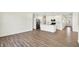 Open-concept living area with white walls and wood-look floors, leading to a kitchen at 19726 Highclere Ln, Sheridan, IN 46069