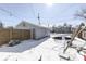 Backyard with a trampoline, shed and a wooden fence, all dusted with snow on a sunny day at 221 Herriott St, Franklin, IN 46131