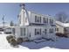 Charming two-story home with a white exterior, shutters, a screened-in porch, and snow-covered front yard at 221 Herriott St, Franklin, IN 46131