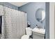 Bathroom with a blue wall, sink and a shower curtain with a floral pattern at 2709 Jackson St, Indianapolis, IN 46222