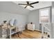 Bedroom featuring hardwood floors, a ceiling fan, desk, and a window with a security gate at 2709 Jackson St, Indianapolis, IN 46222