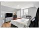 Spacious bedroom featuring hardwood floors, a television, and gray walls at 2709 Jackson St, Indianapolis, IN 46222