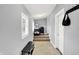 Light gray hallway featuring tiled floors, access to several doors, and a small table with a window at 2709 Jackson St, Indianapolis, IN 46222