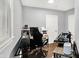 Office with dark hardwood floors and light-colored walls, an office chair and a corner of the window light at 2709 Jackson St, Indianapolis, IN 46222