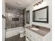 Bathroom with modern design, gray-toned stone surround tub, modern vanity and black herringbone floor at 2828 N Illinois St, Indianapolis, IN 46208