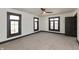 Spacious bedroom with plush carpet, ceiling fan, three windows, and plenty of natural light at 2828 N Illinois St, Indianapolis, IN 46208
