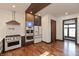 A modern kitchen with stainless steel appliances, a range hood, and hardwood floors at 2828 N Illinois St, Indianapolis, IN 46208