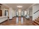 Open-concept living room with white walls, wooden floors, fireplace, and views into kitchen and entryway at 2828 N Illinois St, Indianapolis, IN 46208