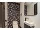 A stylish powder room with custom wallpaper, a modern sink, and a decorative mirror at 2828 N Illinois St, Indianapolis, IN 46208