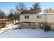 Two-story tan home with a stone facade, visible roof, set against a snowy front yard and blue sky at 2829 Country Estates Dr, Indianapolis, IN 46227
