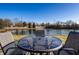 Backyard features a pond with fence, grassy area, and patio seating with a glass table at 3037 Knobstone Ln, Indianapolis, IN 46203