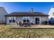 Backyard features a patio with a table, outdoor seating, grill, and grassy lawn at 3037 Knobstone Ln, Indianapolis, IN 46203