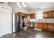 Modern kitchen with stainless steel appliances, wood cabinets, and dark wood-style floors at 3037 Knobstone Ln, Indianapolis, IN 46203