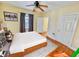 Staged bedroom with hardwood floors, neutral walls, ceiling fan, and large windows with curtains at 3236 Central Ave, Indianapolis, IN 46205