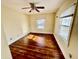 A sunny bedroom with hardwood floors has two windows and a ceiling fan at 3236 Central Ave, Indianapolis, IN 46205