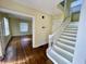 Inviting entryway showcases hardwood floors and a staircase with white painted wood risers and banister at 3236 Central Ave, Indianapolis, IN 46205