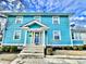Inviting two-story turquoise home with a welcoming front porch and well-maintained yard at 3236 Central Ave, Indianapolis, IN 46205