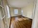 Light-filled living room with gleaming hardwood floors and windows dressed with blinds at 3236 Central Ave, Indianapolis, IN 46205