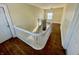 Upstairs landing with wood floors, access to bedrooms and bathrooms, and white wood railings at 3236 Central Ave, Indianapolis, IN 46205