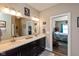Modern bathroom featuring double vanity with dark cabinets, quartz countertop, and a large mirror at 3629 S Meadows Ln, New Palestine, IN 46163
