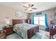 Comfortable bedroom features wood furniture, ceiling fan, and natural light from the window at 3629 S Meadows Ln, New Palestine, IN 46163