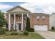 Beautiful two-story brick home boasts stately columns and a well-manicured front yard at 387 Legacy Blvd, Greenwood, IN 46143