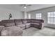 Bright living room features plush sectional sofa, ceiling fan, and large windows at 387 Legacy Blvd, Greenwood, IN 46143
