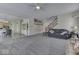 Spacious living room features plush carpet, staircase, and a comfortable black leather sofa at 387 Legacy Blvd, Greenwood, IN 46143