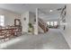 Open concept living room with dining area featuring neutral colors, large windows, and access to the staircase at 387 Legacy Blvd, Greenwood, IN 46143