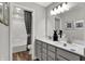 Bright bathroom features double sink vanity with gray cabinets, quartz countertop and decorative art at 5314 Pelion Pl, McCordsville, IN 46055