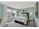 This bedroom features stylish decor, large windows, and a cozy bed with decorative pillows and a teal color scheme at 5314 Pelion Pl, McCordsville, IN 46055