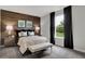 Comfortable bedroom featuring a wood accent wall, plush bedding, and bright natural light from a window at 5314 Pelion Pl, McCordsville, IN 46055