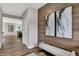 Stylish hallway with wood-look floors, wood-panel accent wall, and comfortable bench seating creating a welcoming ambiance at 5314 Pelion Pl, McCordsville, IN 46055