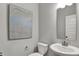 A pristine powder room features a pedestal sink, modern art, and neutral tones for a clean and sophisticated look at 5314 Pelion Pl, McCordsville, IN 46055