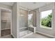 Modern tiled shower with a glass enclosure, built-in seat, and bright window offering a luxurious bathing experience at 5314 Pelion Pl, McCordsville, IN 46055