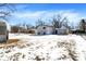 Spacious, snowy backyard with detached garage and surrounding trees at 5614 Personality Ct, Indianapolis, IN 46237