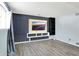 A finished basement features vinyl flooring and modern entertainment area with mounted tv and shelving at 5614 Personality Ct, Indianapolis, IN 46237