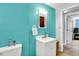 Well-lit bathroom featuring a white vanity and a turquoise accent wall at 5614 Personality Ct, Indianapolis, IN 46237