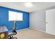 Bedroom featuring a chair, blue accent wall, and carpeted flooring, a large window for natural light at 5614 Personality Ct, Indianapolis, IN 46237