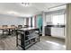 Open kitchen with stainless steel appliances, island, and wood dining table, perfect for entertaining in this newly renovated home at 5614 Personality Ct, Indianapolis, IN 46237