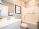 Stylish bathroom featuring a vanity with a mirror, a shower with bathtub, and elegant tiling at 5879 Handbell Ln, Greenwood, IN 46143